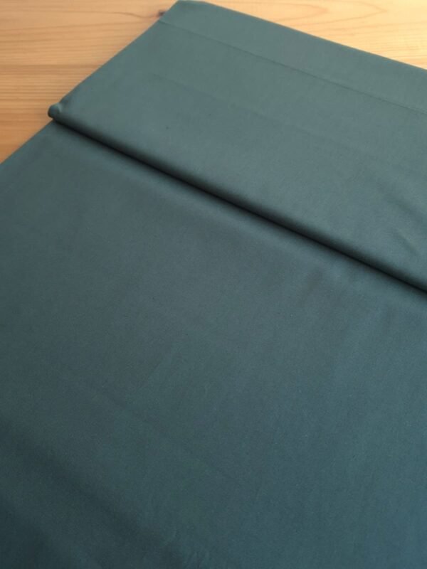 Tela sarga lisa en color verde oscuro vista en ángulo de 45 grados