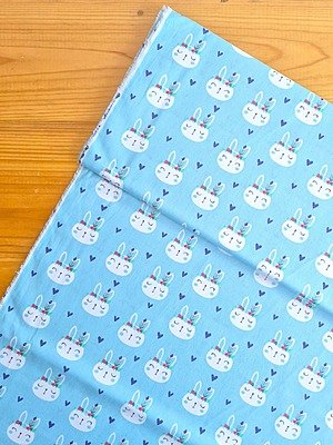 Tela Sarga Caras de Conejos con Plumas Fondo Celeste