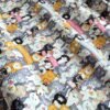 Tela sarga con estampado de caras de gatos de colores dispuesta en forma de olas