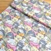 Tela sarga con estampado de gatos kawaii en tono rosa vista en ángulo de 45 grados