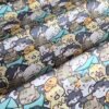 Tela sarga con estampado de gatos kawaii en tono celeste dispuesta en forma de olas