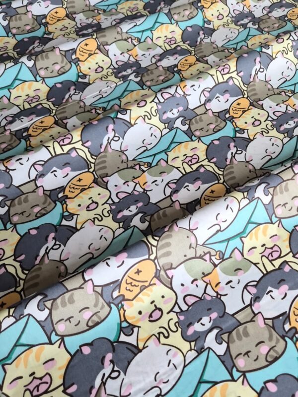 Tela sarga con estampado de gatos kawaii en tono celeste dispuesta en forma de olas