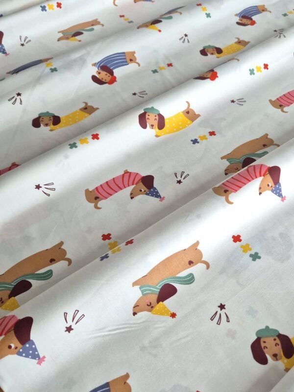 Tela sarga con estampado de perros salchicha dispuesta en forma de olas