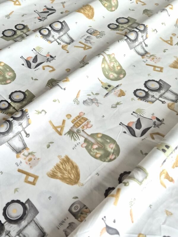 Tela sarga con estampado de tractores y animales de granja dispuesta en forma de olas