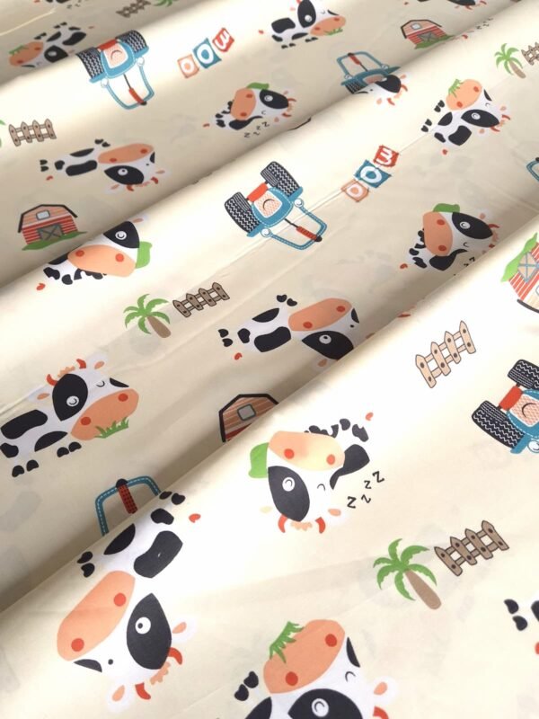 Tela sarga con estampado de vaquitas en la granja dispuesta en forma de olas