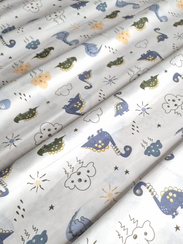 Tela sarga con estampado de dinosaurios y nubes con rayos dispuesta en forma de olas