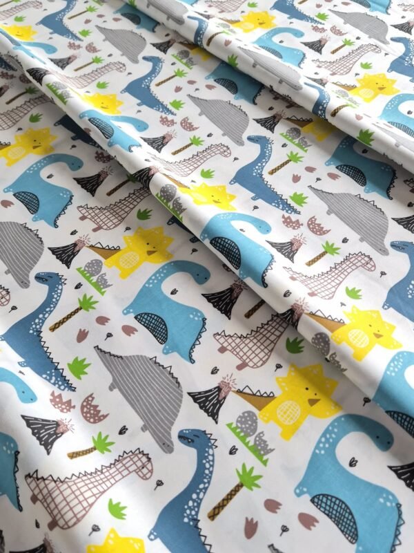 Tela sarga con estampado de dinosaurios y volcanes dispuesta en forma de olas