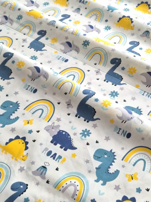 Tela sarga con estampado de dinosaurios y arcoíris con texto Roarrr Dino dispuesta en forma de olas