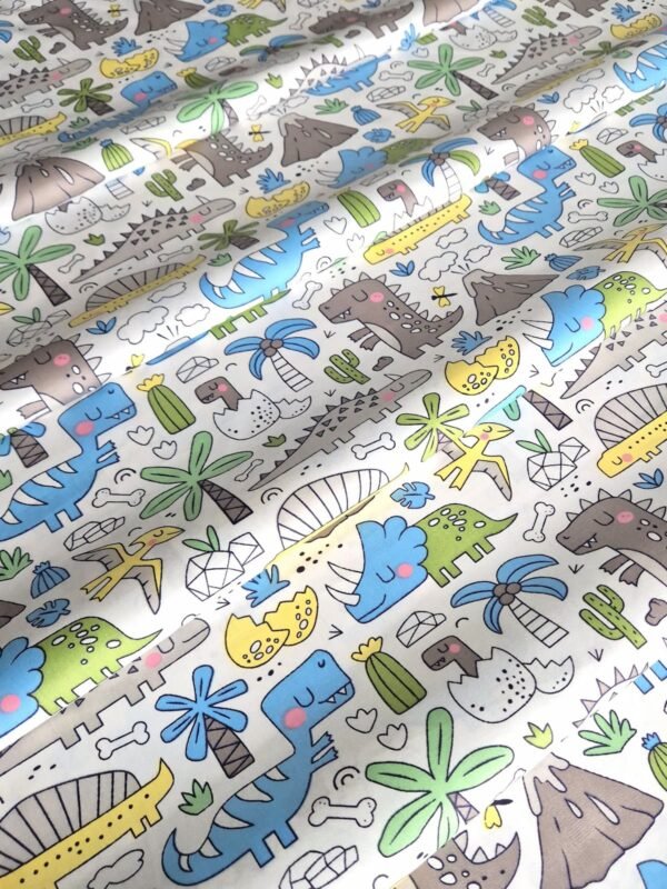 Tela sarga con estampado de dinosaurios y palmeras tropicales dispuesta en forma de olas