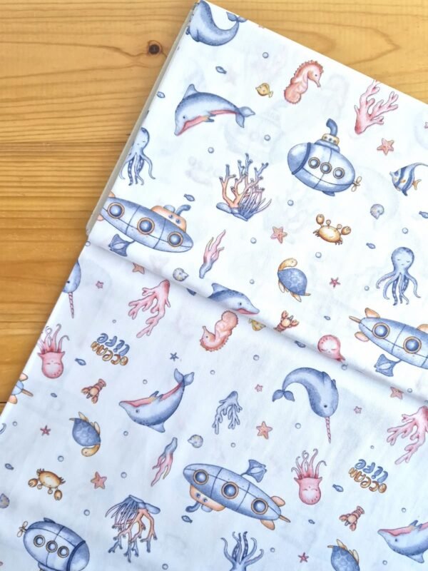 Vista superior de tela sarga con estampado de vida marina sobre fondo blanco