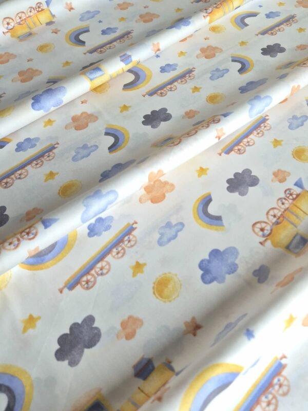 Tela sarga con estampado de trenes arcoíris y nubes dispuesta en forma de olas