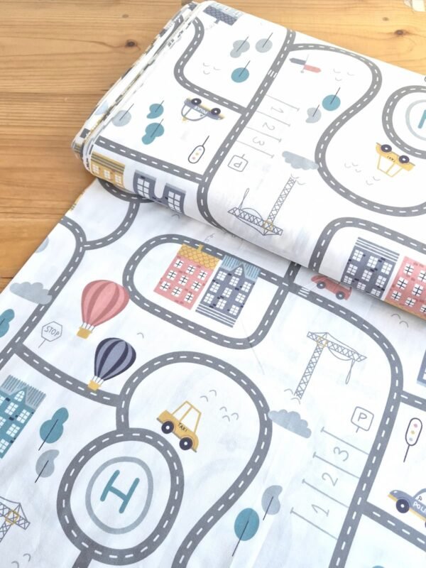 Tela sarga con diseño urbano de calles y edificios, vista en ángulo para mostrar textura del tejido