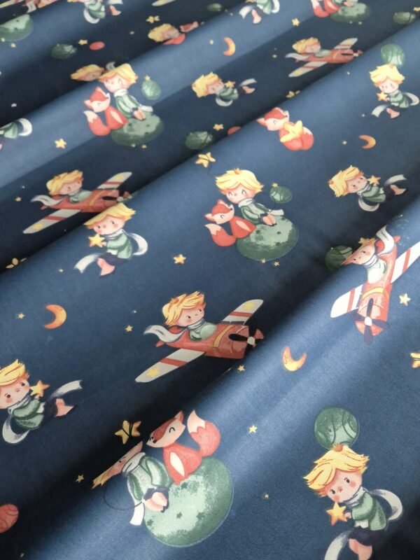 Tela sarga con estampado del Principito sobre fondo azul oscuro dispuesta en forma de olas