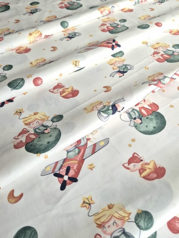 Tela sarga con estampado del Principito sobre fondo blanco dispuesta en forma de olas