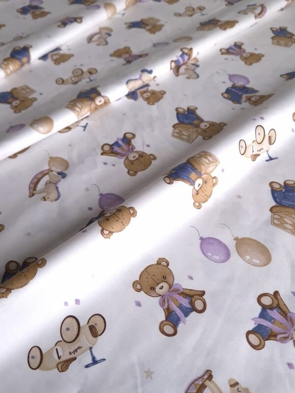 Tela sarga con estampado de osos de peluche leyendo dispuesta en forma de olas