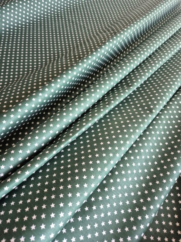 Tela sarga con estrellas verdes oscuras en forma de ondas para mostrar textura y caída