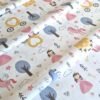 Tela sarga con estampado de princesas, unicornios y castillos dispuesta en forma de olas