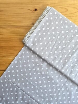 Vista superior de la tela sarga con estrellas en color gris claro