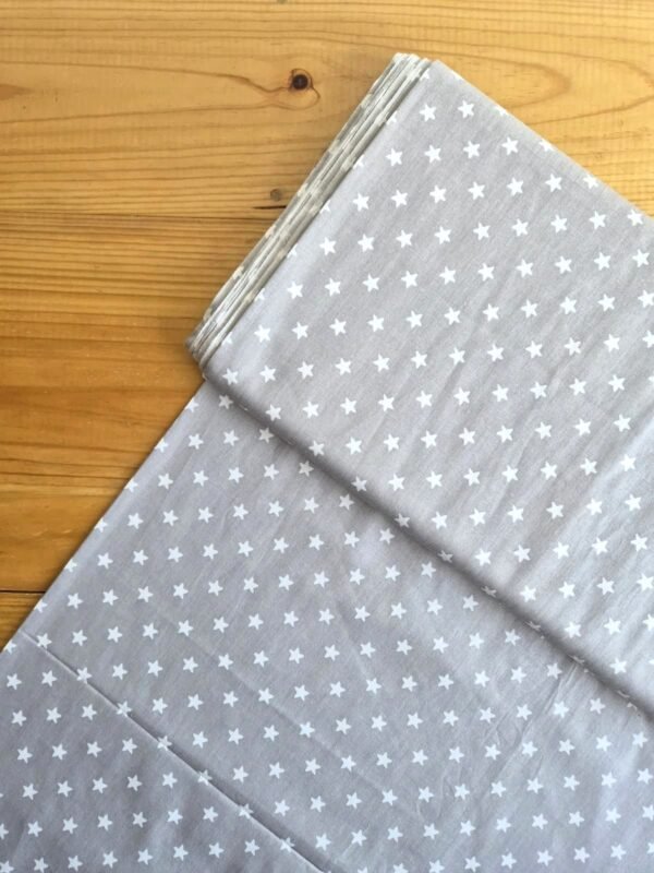 Vista superior de la tela sarga con estrellas en color gris claro