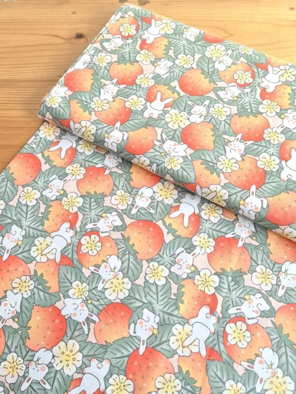 Tela Sarga con frutillas y conejos naranjas vista en ángulo de 45 grados