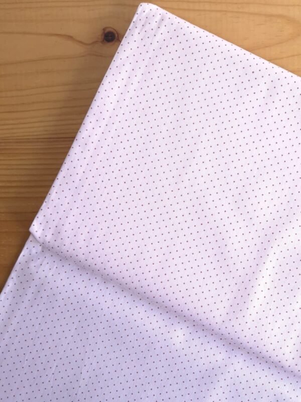 Vista superior de la tela sarga rosa pálido con lunares blancos pequeños