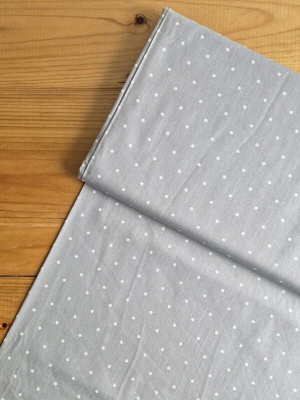Vista superior de la tela sarga gris con lunares blancos