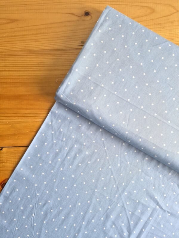 Vista superior de la tela sarga azul con lunares blancos