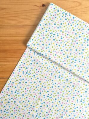 Vista superior de la tela sarga blanca con lunares multicolor