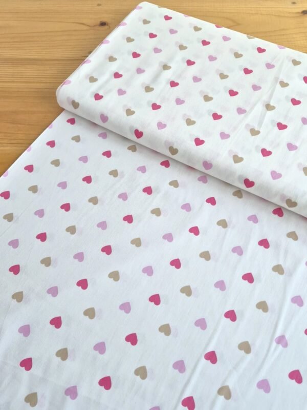 Tela Sarga con corazones multicolor sobre fondo blanco vista en ángulo de 45 grados