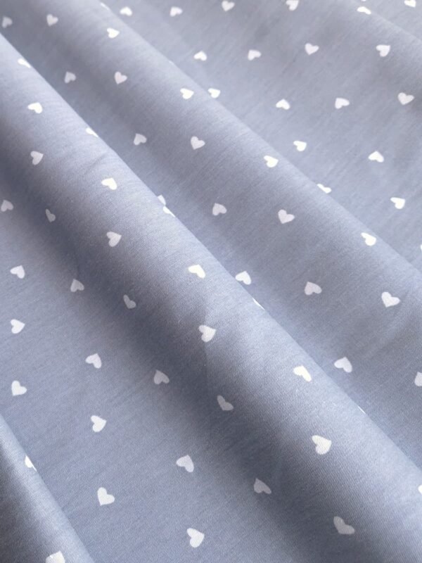 Tela Sarga con corazones blancos en fondo gris claro doblada en forma de olas