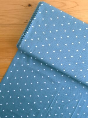 Tela Sarga con corazones blancos sobre fondo azul petróleo vista desde arriba