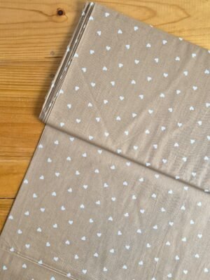 Tela Sarga con corazones blancos sobre fondo beige oscuro vista desde arriba