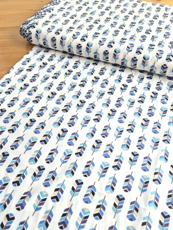 Tela sarga blanca con flechas azules y lilas vista en ángulo para mostrar profundidad y textura