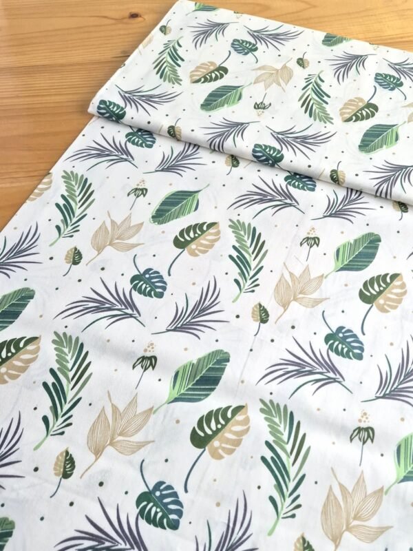 Tela sarga con hojas tropicales verdes sobre fondo blanco, vista en ángulo para mostrar textura y profundidad