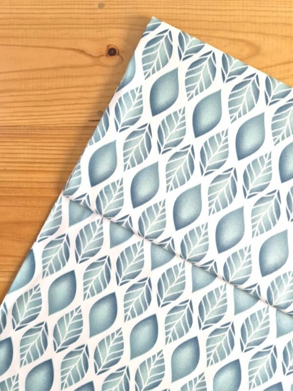 Vista superior de tela sarga con diseño de hojas en tonos verdes con efecto degradado