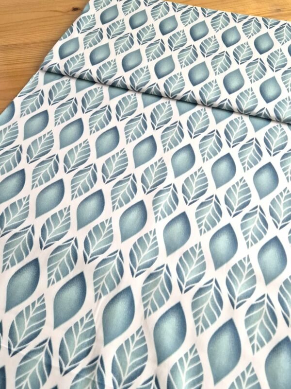 Tela sarga con hojas verdes en degradado, vista en ángulo para mostrar textura y volumen