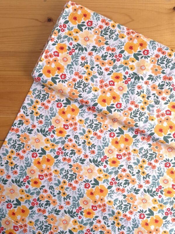 Tela Sarga con flores amarillas y naranjas sobre fondo blanco vista desde arriba