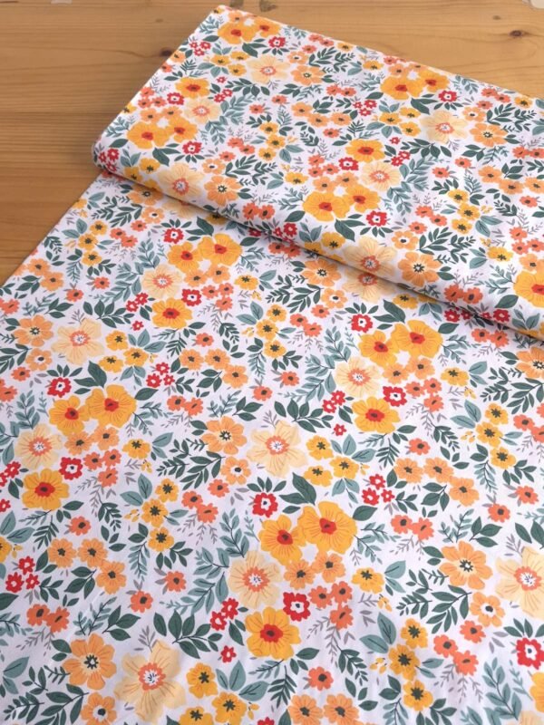 Tela Sarga con flores amarillas y naranjas sobre fondo blanco vista en ángulo de 45 grados