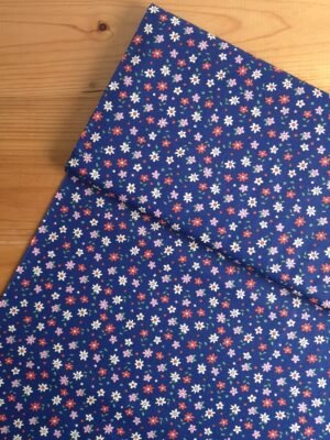 Tela Sarga floral multicolor sobre fondo azul marino vista desde arriba