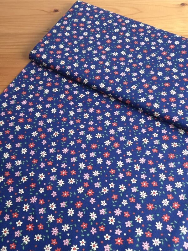 Tela Sarga floral multicolor sobre fondo azul marino vista en ángulo de 45 grados