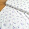 Tela Sarga floral lila y rosa fondo blanco vista en ángulo de 45 grados