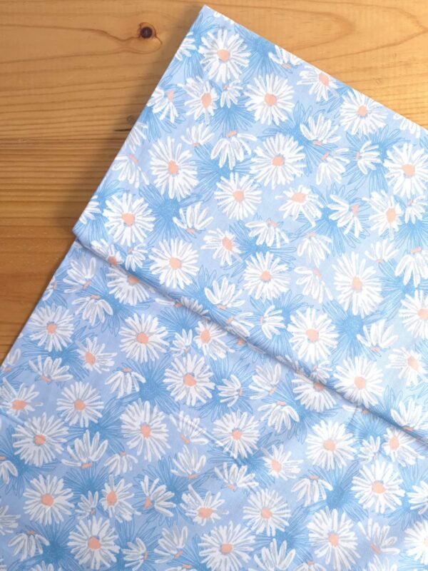 Tela Sarga con margaritas blancas sobre fondo celeste vista desde arriba