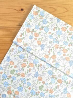 Vista superior de tela sarga con estampado floral multicolor y dibujos sobre fondo amarillo