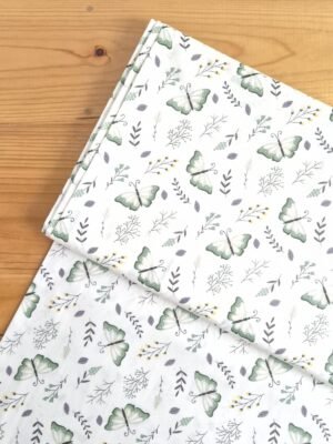 Vista superior de tela sarga blanca con estampado de mariposas y hojas en colores suaves