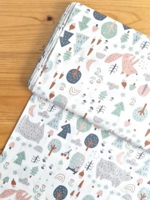 Vista superior de tela sarga con estampado de animales del bosque y elementos naturales sobre fondo blanco