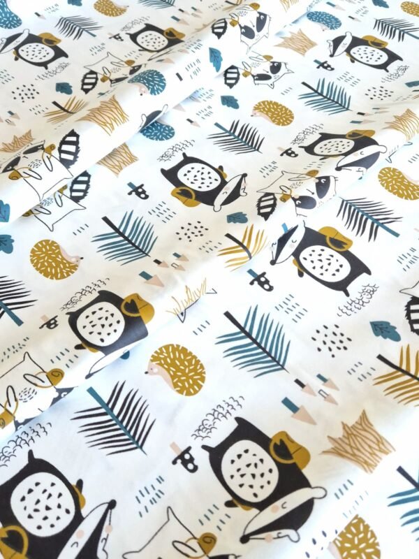 Tela sarga con estampado de mapaches y pinos del bosque dispuesta en forma de olas