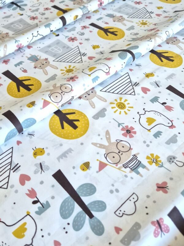 Tela sarga con estampado de conejos, árboles y flores del bosque dispuesta en forma de olas