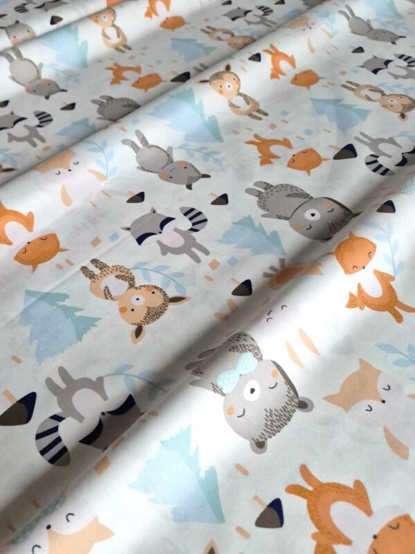 Tela sarga con estampado de mapaches, osos y zorros del bosque dispuesta en forma de olas