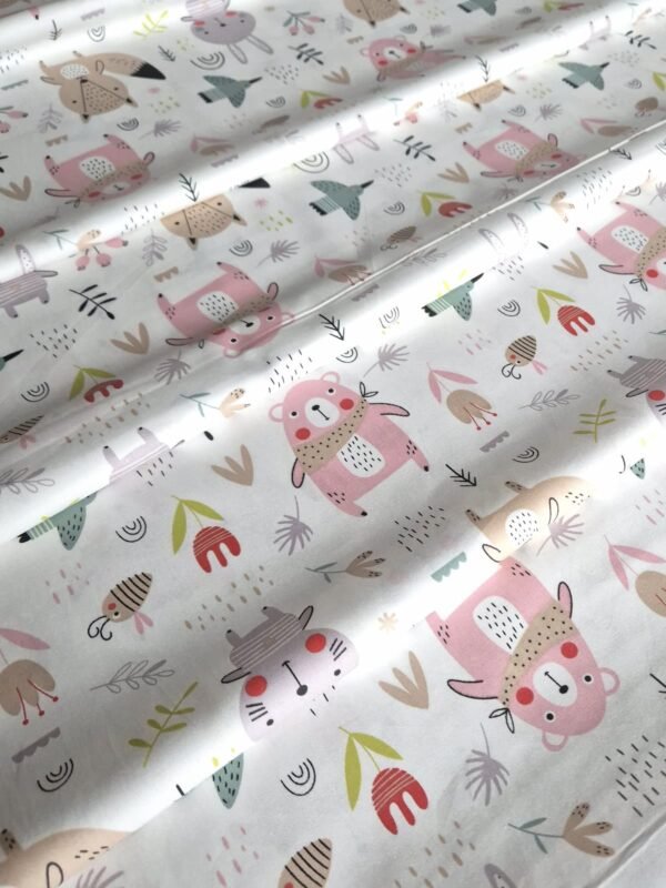 Tela sarga con estampado de osos y animales en tonos pastel rosa dispuesta en forma de olas