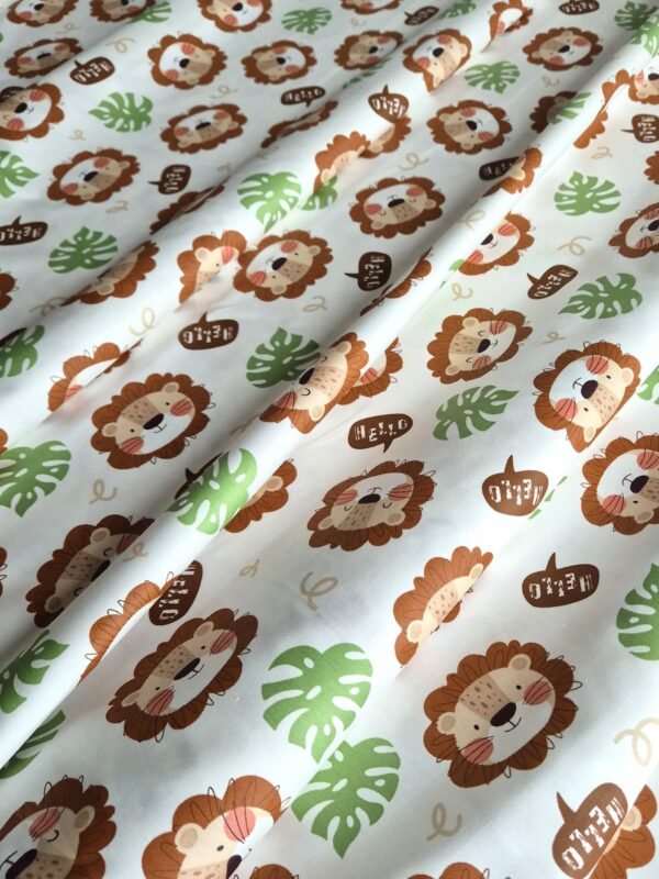 Tela sarga con estampado de caras de leones y hojas verdes dispuesta en forma de olas